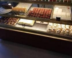 Cakes, pastries and small desserts in the glass display case at Villani’s Bakery.