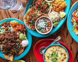 An overhead view of colorful meal plates and dips at Paco’s Tacos & Tequila.