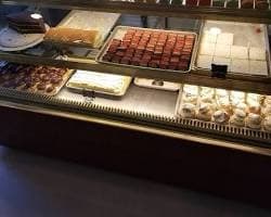 Cakes, pastries and small desserts in the glass display case at Villani’s Bakery.