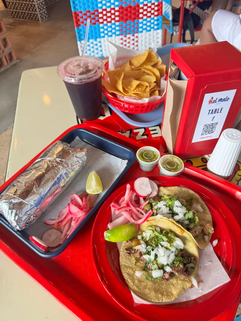 Tacos, chips and drinks on trays at El Malo Tacos in Charlotte