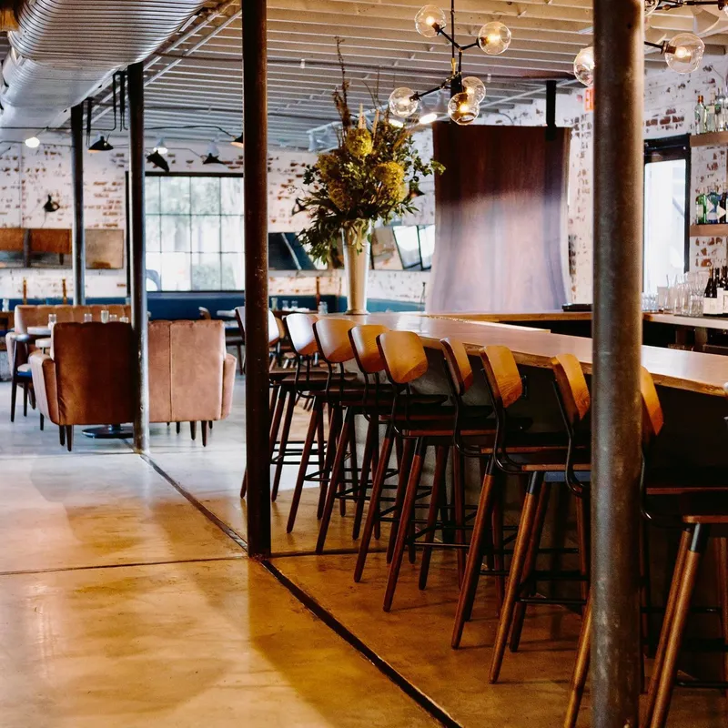 Wooden floors, tables and plants at Lincoln Street Kitchen & Cocktails in Charlotte
